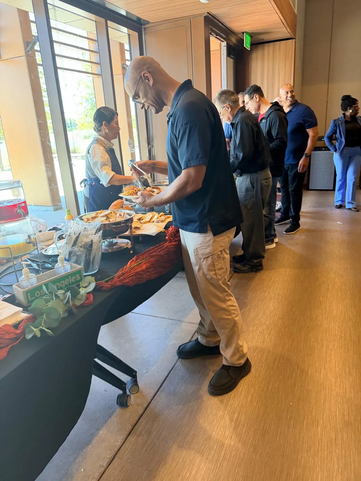 County legal staff serving roasted chicken, spaghetti marinara, and baguettes during midday lunch service